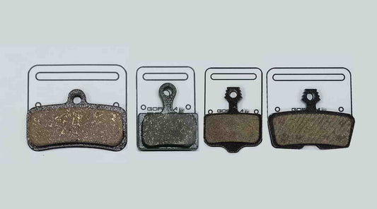 Comparison of new aluminium backplate brake pad dimensions next to standard steel-backed pad showing shape and thickness differences