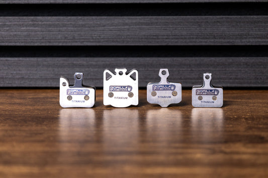 Gorilla Brakes Factory Racing titanium-backed disc brake pads lineup for road and MTB bikes, designed for high-performance and low-noise braking.