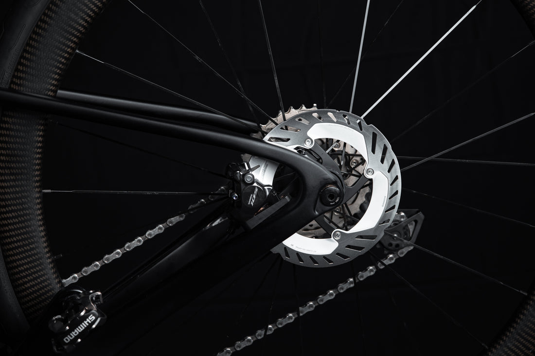 Close-up of Shimano 105 hydraulic disc brake caliper and rotor on a road bike rear wheel