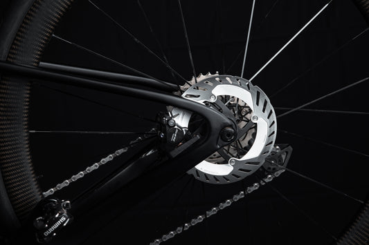 Close-up of Shimano 105 hydraulic disc brake caliper and rotor on a road bike rear wheel