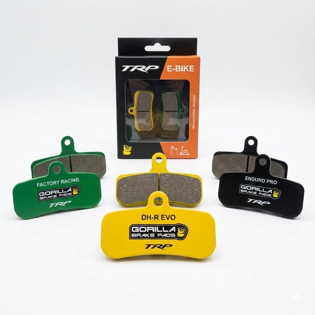 A product display showing a collection of Gorilla Brakes disc brake pads designed for TRP E-Bikes. The image features pairs of yellow DH-R EVO pads, green Factory Racing pads, and black Enduro Pro pads